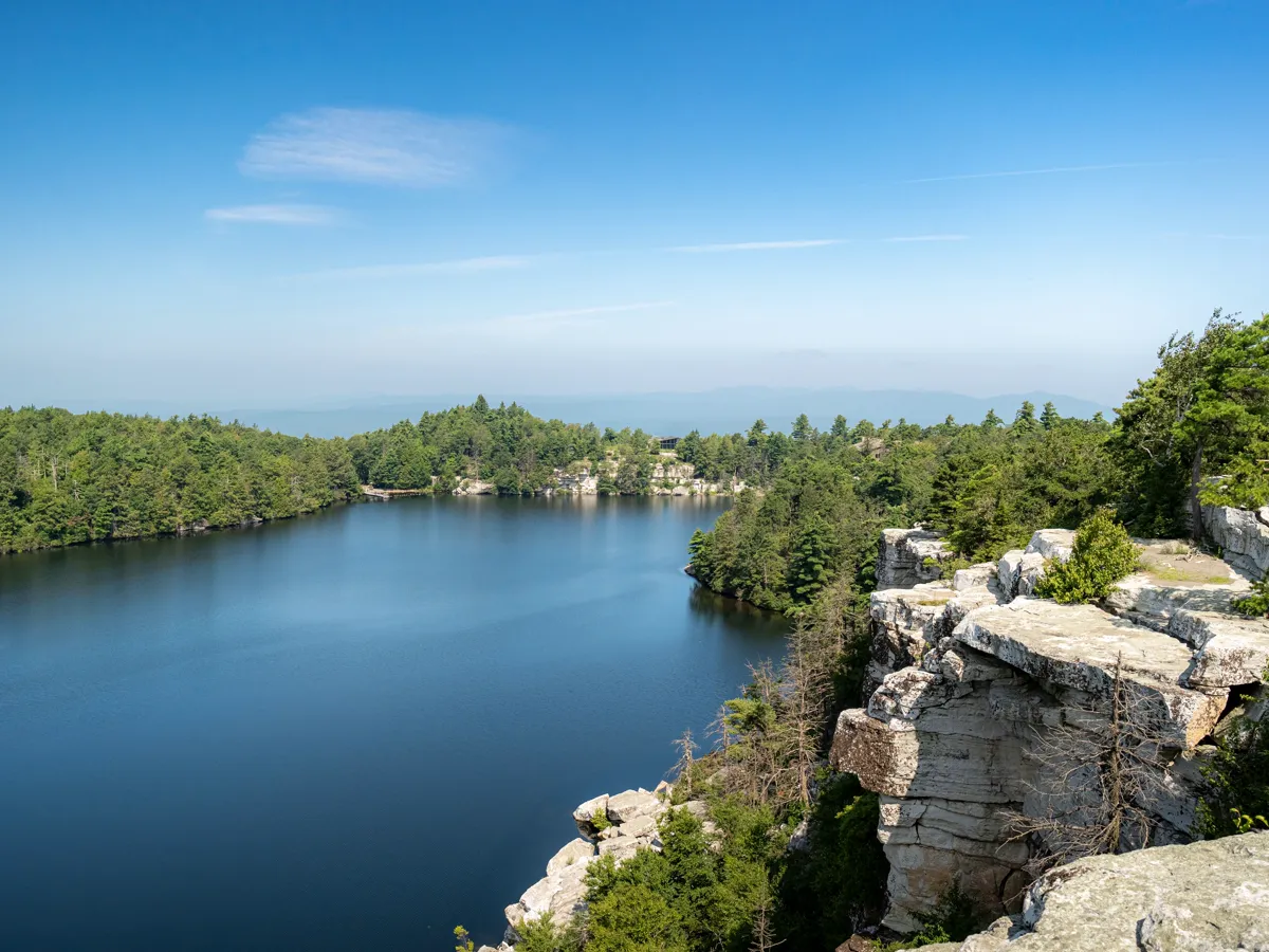 White rock cliff above a clear woodland lake